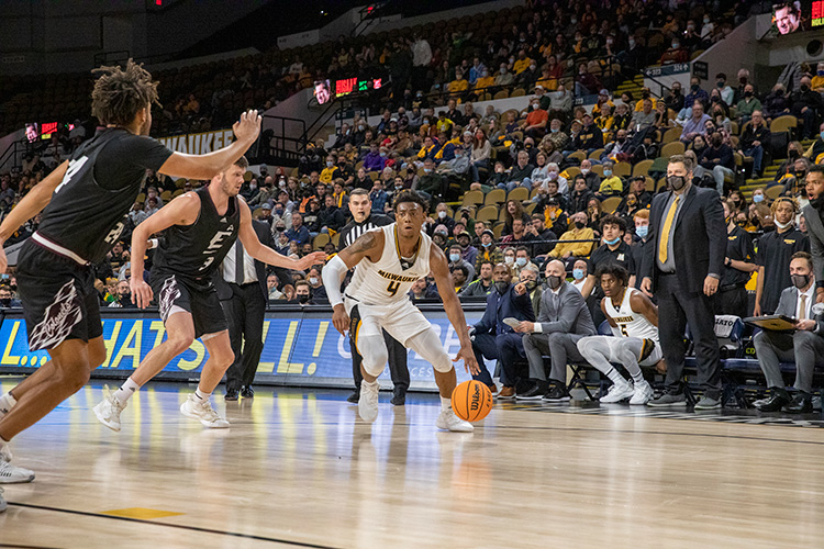 UWM men's basketball player dribbling during a game at Panther Arena