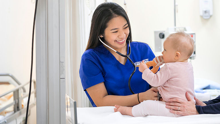 UWM nursing student using stethoscope on a baby
