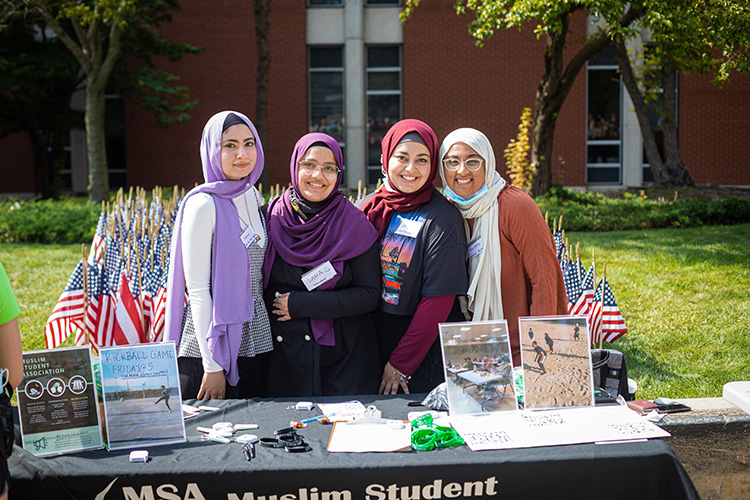 Four UWM hijabi students standing at Muslim Student Association table