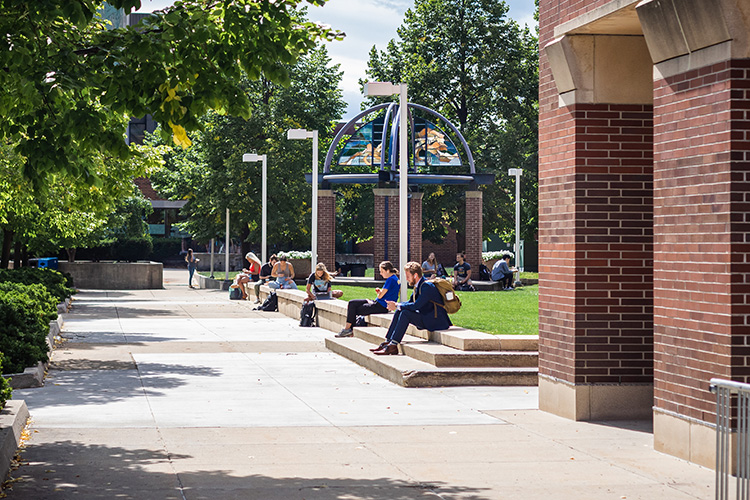 UWM students in summer sitting in campus common spaces and studying