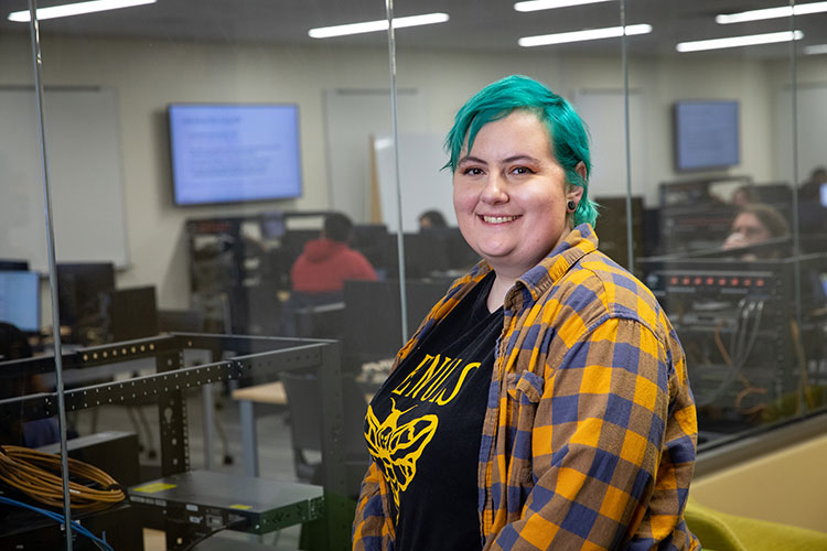 UWM IST student with blue hair smiling at camera