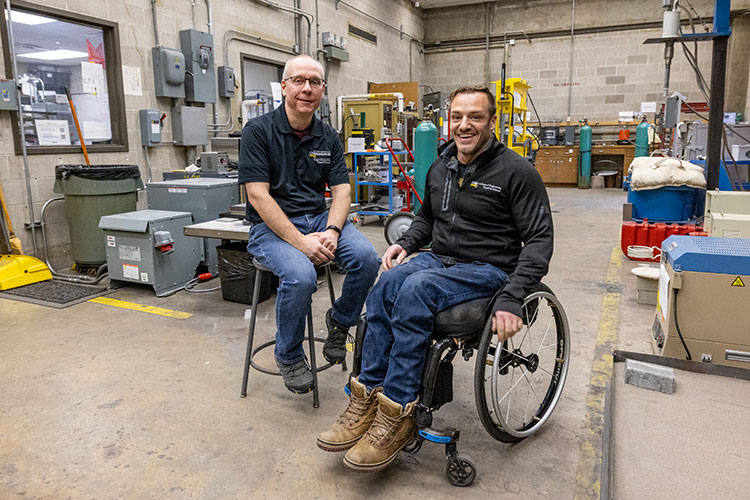 Materials engineering student James in wheelchair sitting next to UWM engineering professor