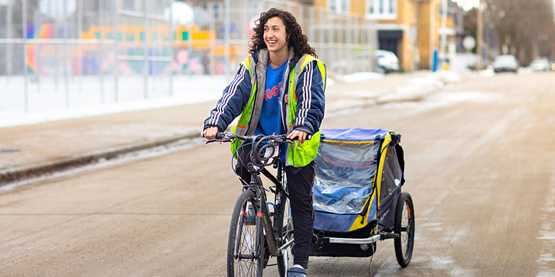UWM student Gianni Vaccaro delivering meals on a bicycle