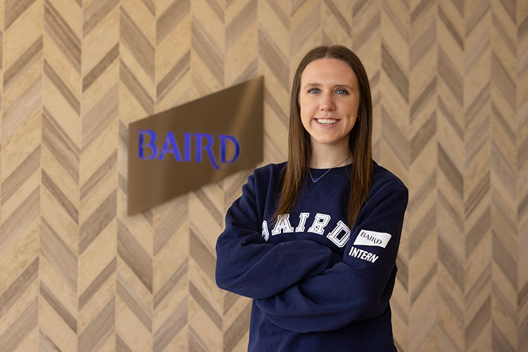 UWM student Gabby wearing a Baird sweater and smiling