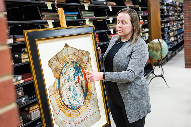 Marcy Bidney, curator of the American Geographical Society Library, points to details on the Leardo Mappamundi, a map of the world hand-drawn in 1452