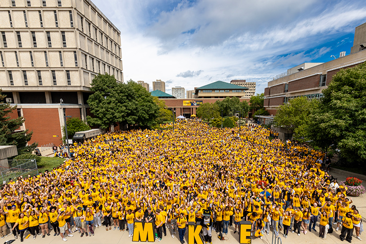 Nearly 4,000 UWM students in yellow shirts pose for a group photo