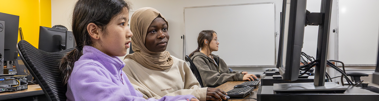 Young girls using computers in a computer lab during a Girls Who Code event.